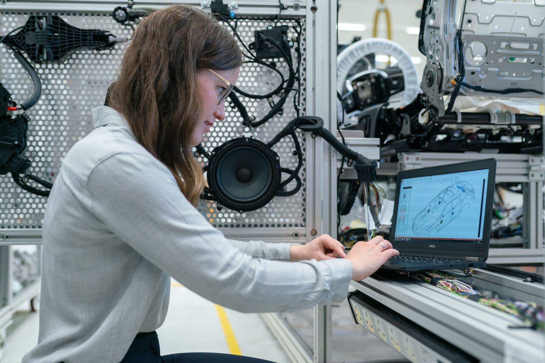 Engineer using CAD software beside a physical test rig